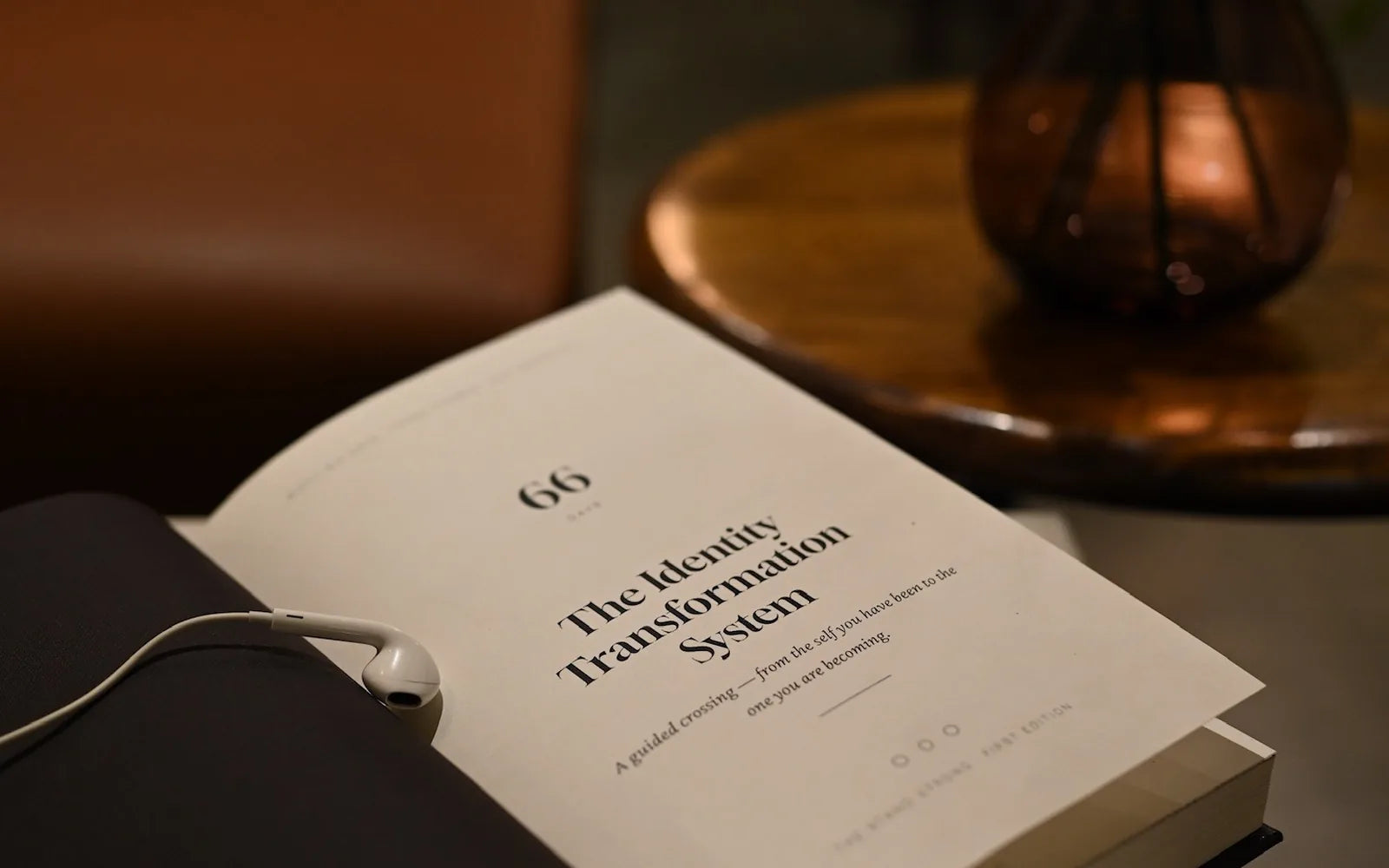 The journal open at its title page on a table, headphones beside it.