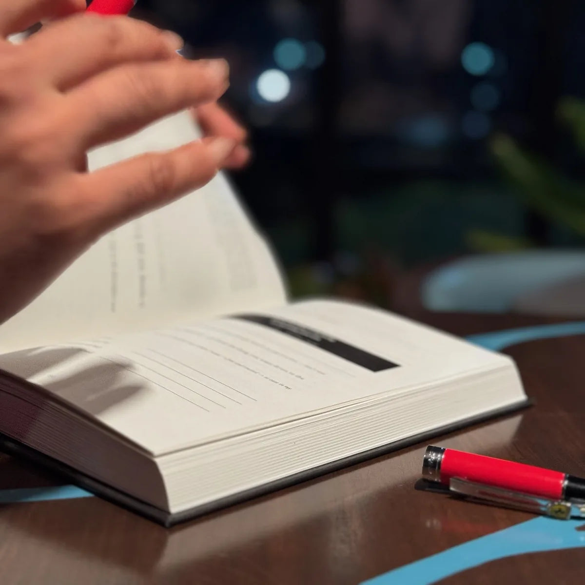 Hands turning the pages of the journal at night.